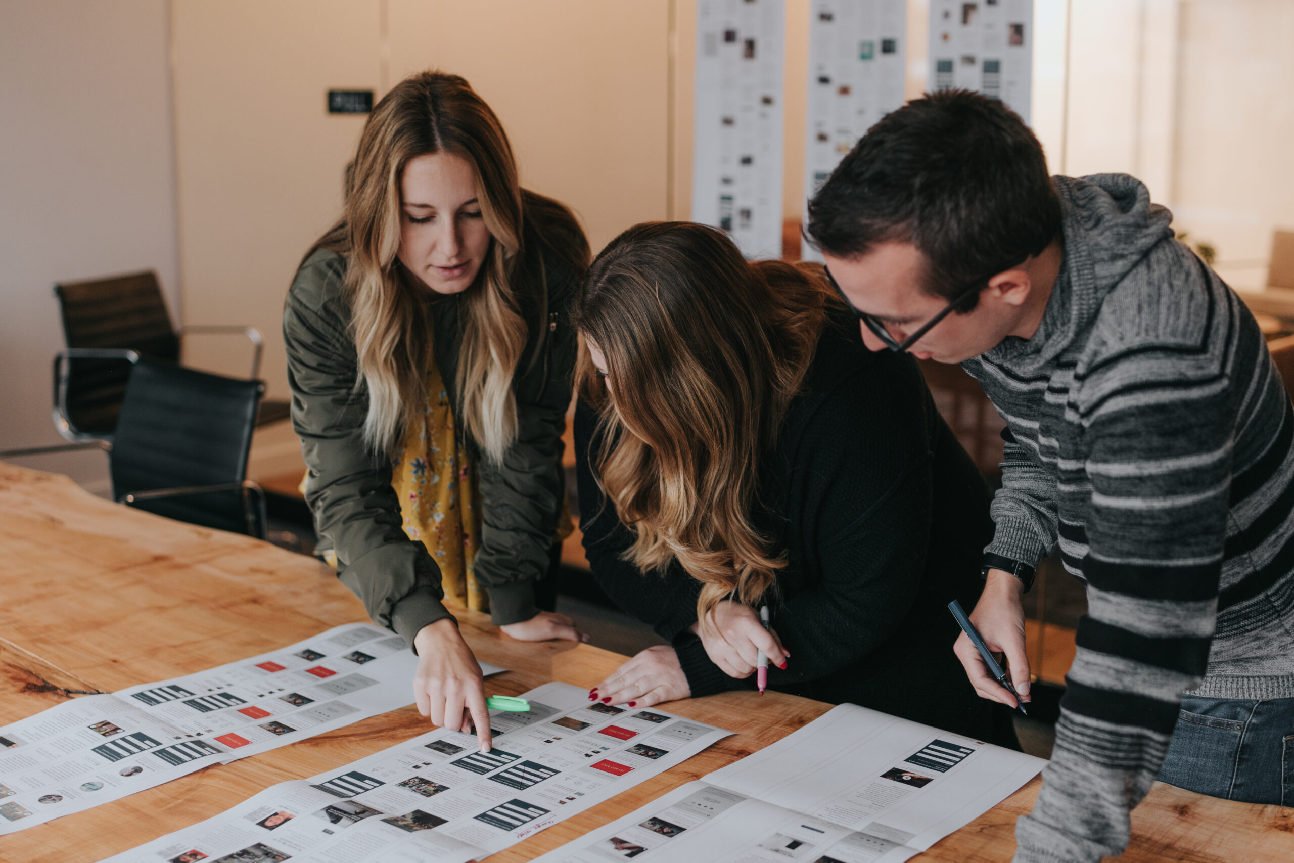 A trio of coworkers reviewing creative designs.