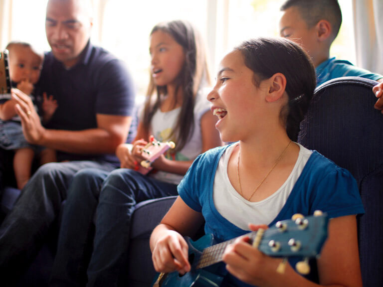 A family playing guitar and singing together.