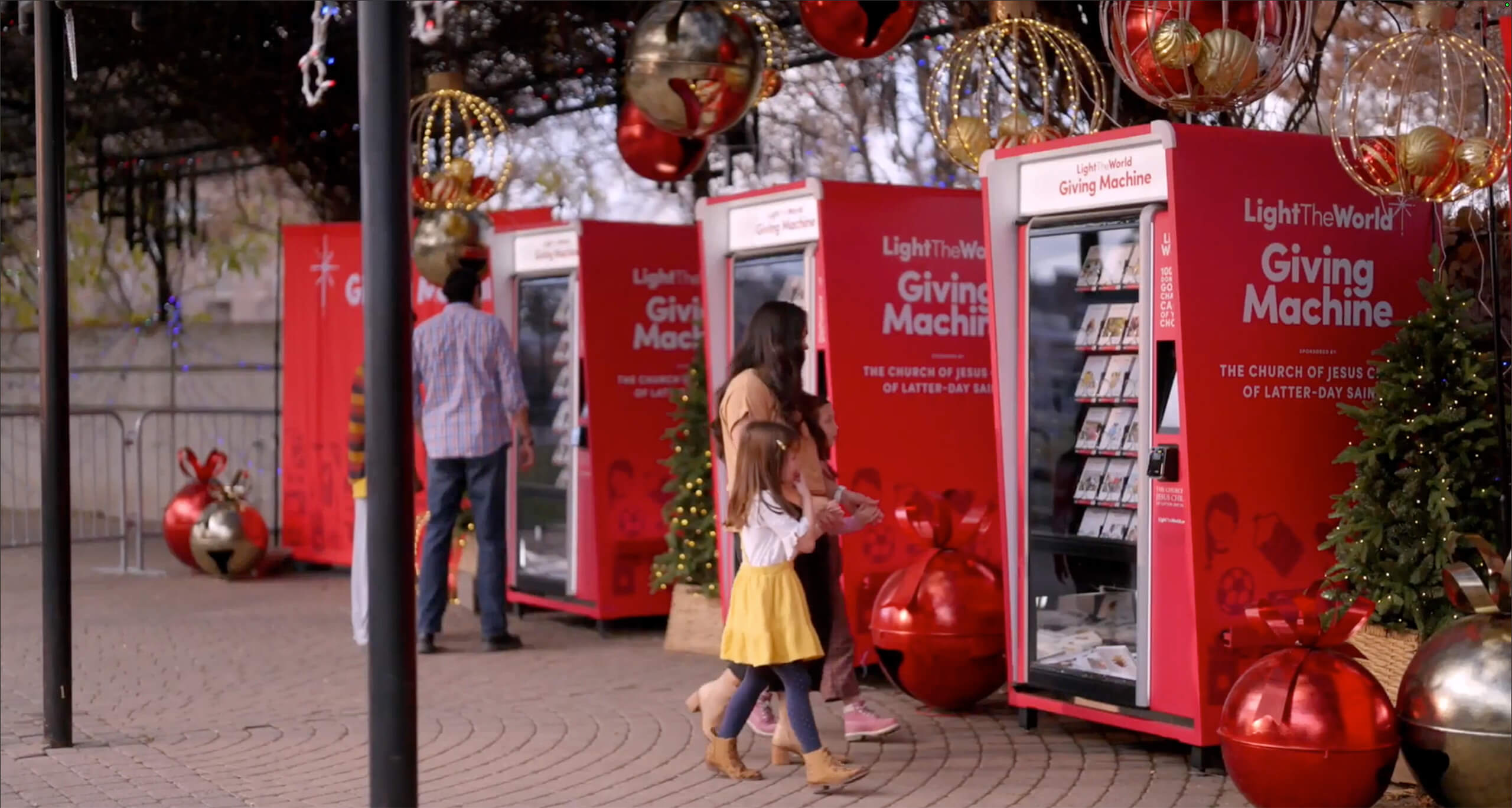 An image of a family walking toward the Giving Machines at Christmas time.