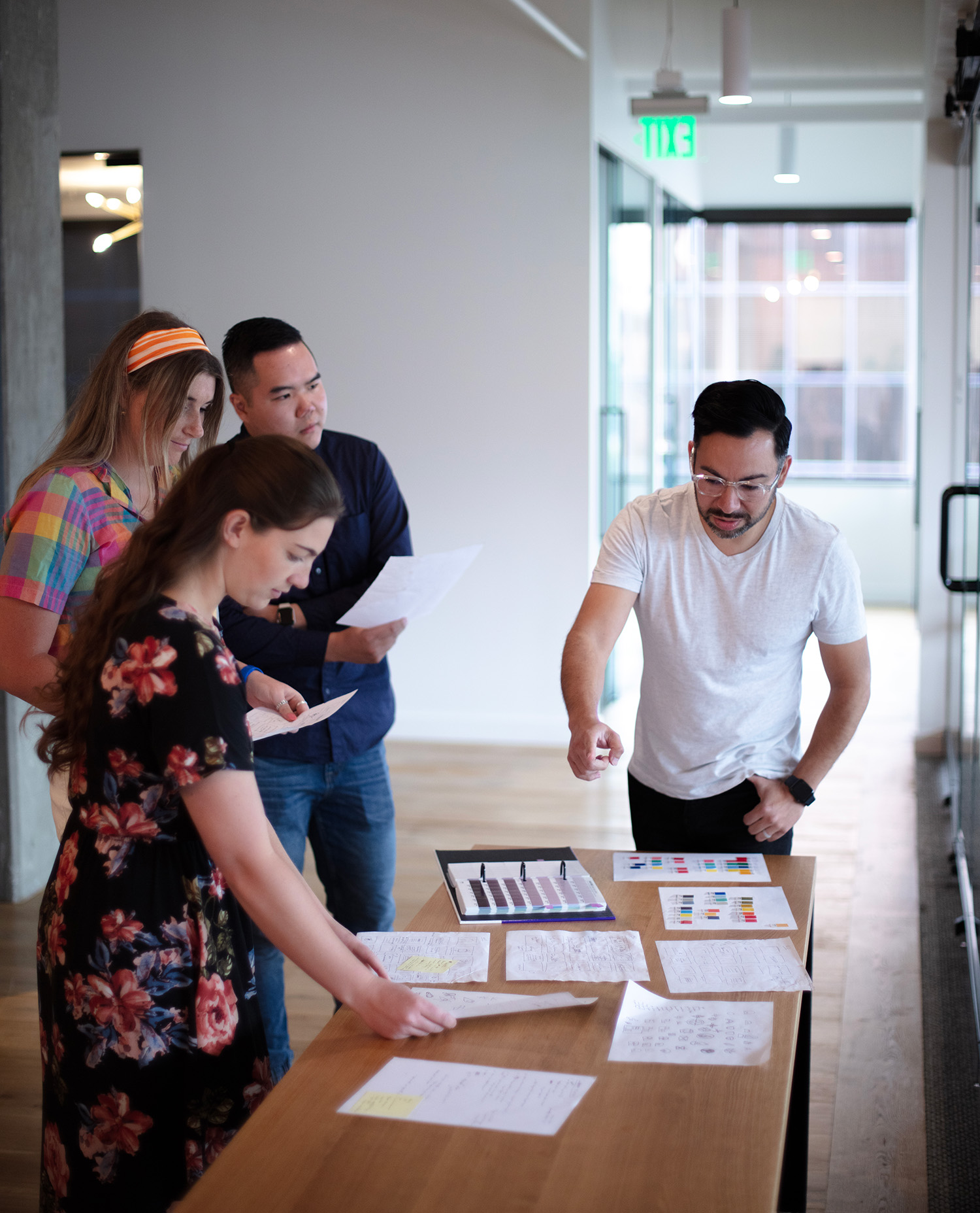 Coworkers standing to collaborate around a table.